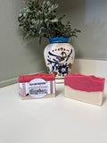 Cranberry Fig & Vanilla Apple Soap displayed beside a decorative vase, showcasing its vibrant colors and textures.
